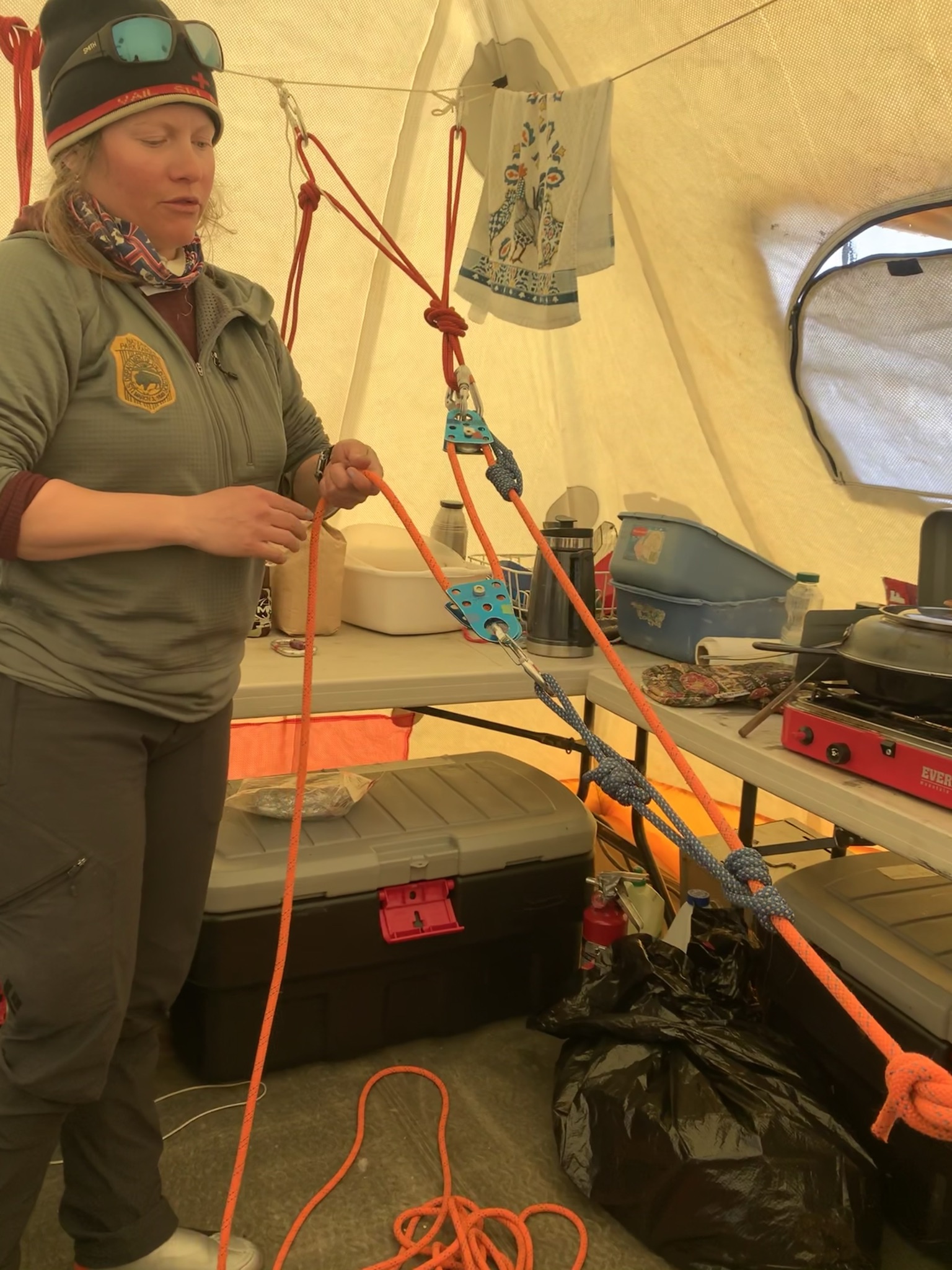 A ranger practices rope rigging in a cook tent