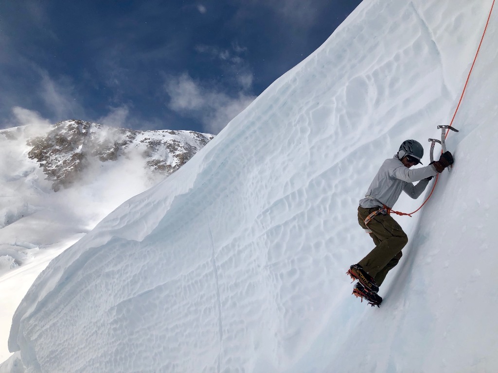 Ice Climbing A roped ice climber digs into a steep face
