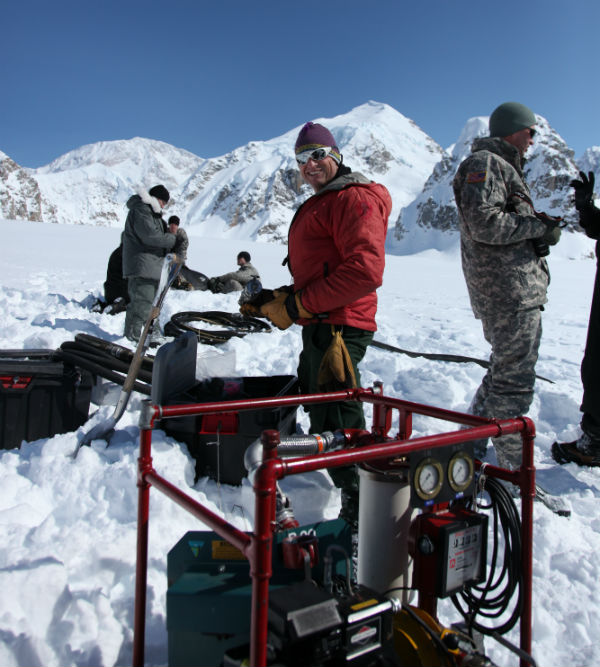 Ranger and military personnel on glacier with fueling equpment.
