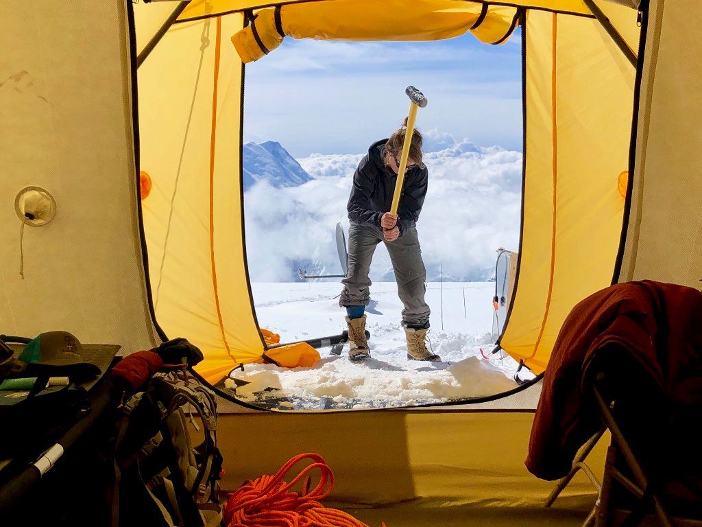View from a tent of a woman swinging a mallet