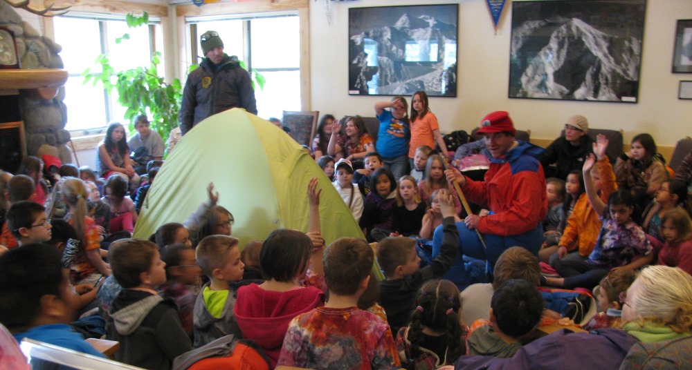 Students surround a tent and two climbers at the Talkeetna Ranger Station Students surround a tent and two climbers at the Talkeetna Ranger Station
