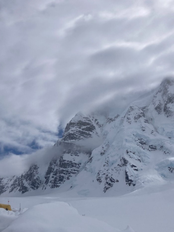 Rescue from the North Buttress of Mt. Hunter Mountain range covered in snow and surrounded by clouds.
