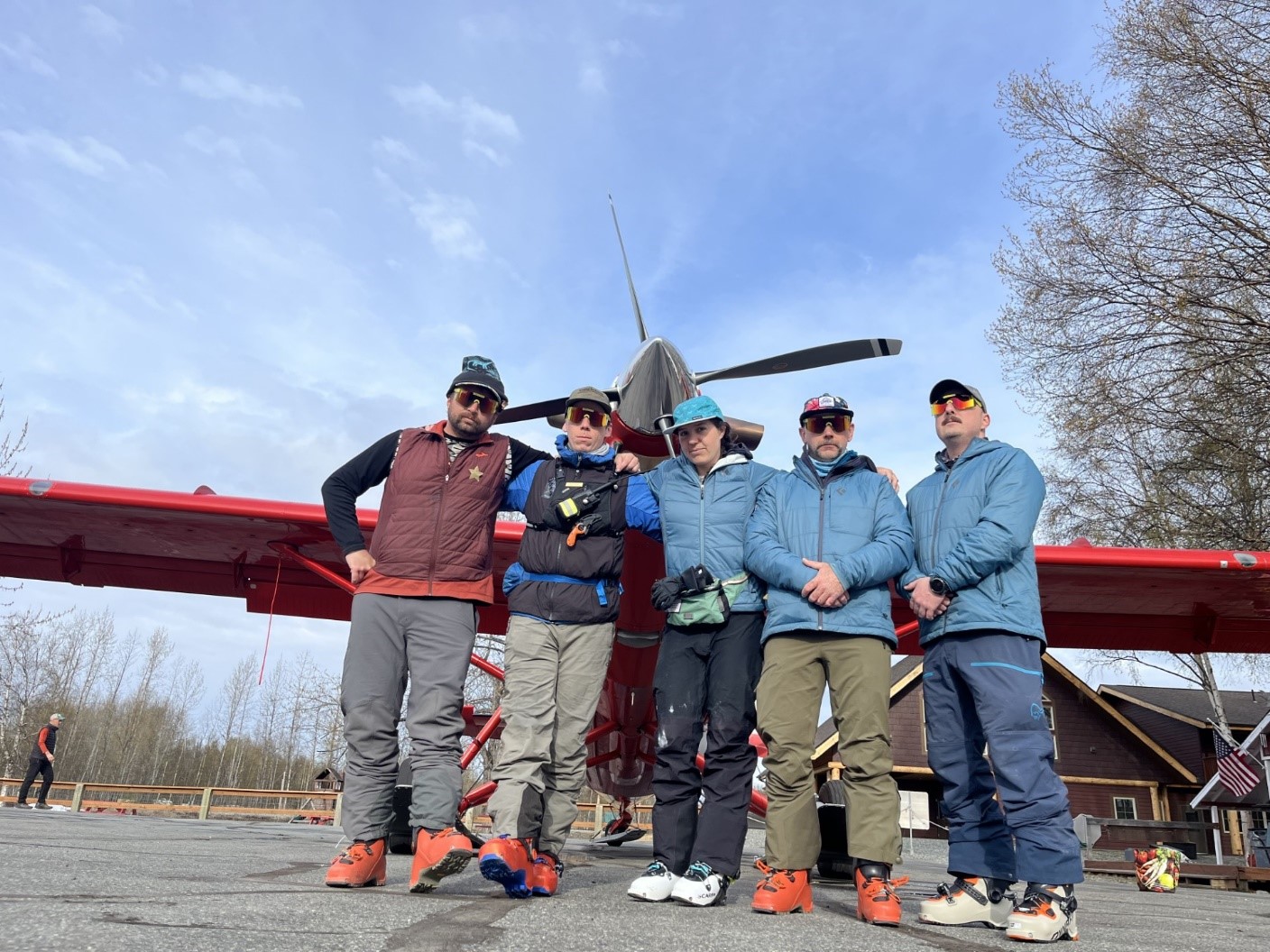 Fanny packs Five mountaineering rangers pose in front of a red plane
