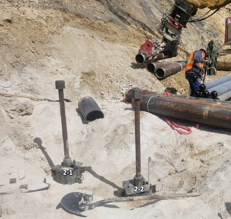 Micropiles - FHWA_BGC Photo Two pieces of metal with threads stick out from the ground.