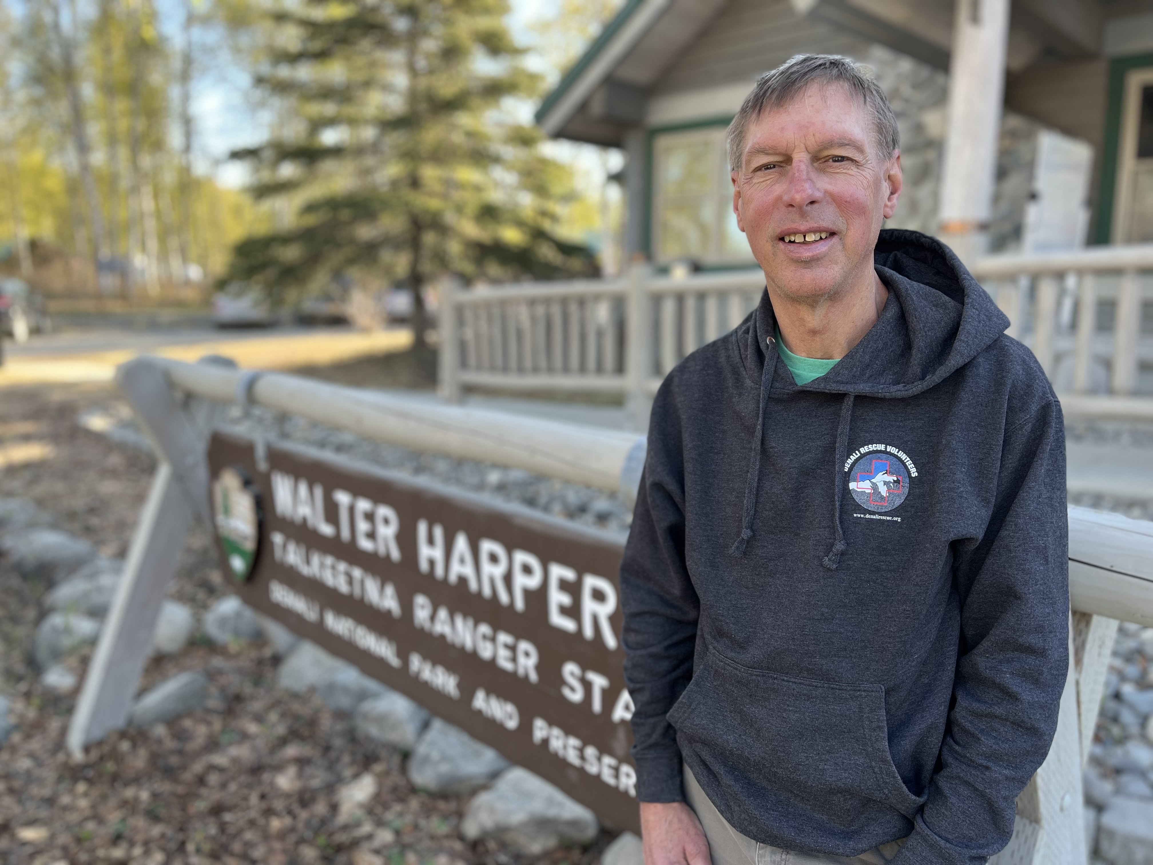 Steve Mock, president of Denali Rescue Volunteers A man standing outdoors next to the ranger station sign