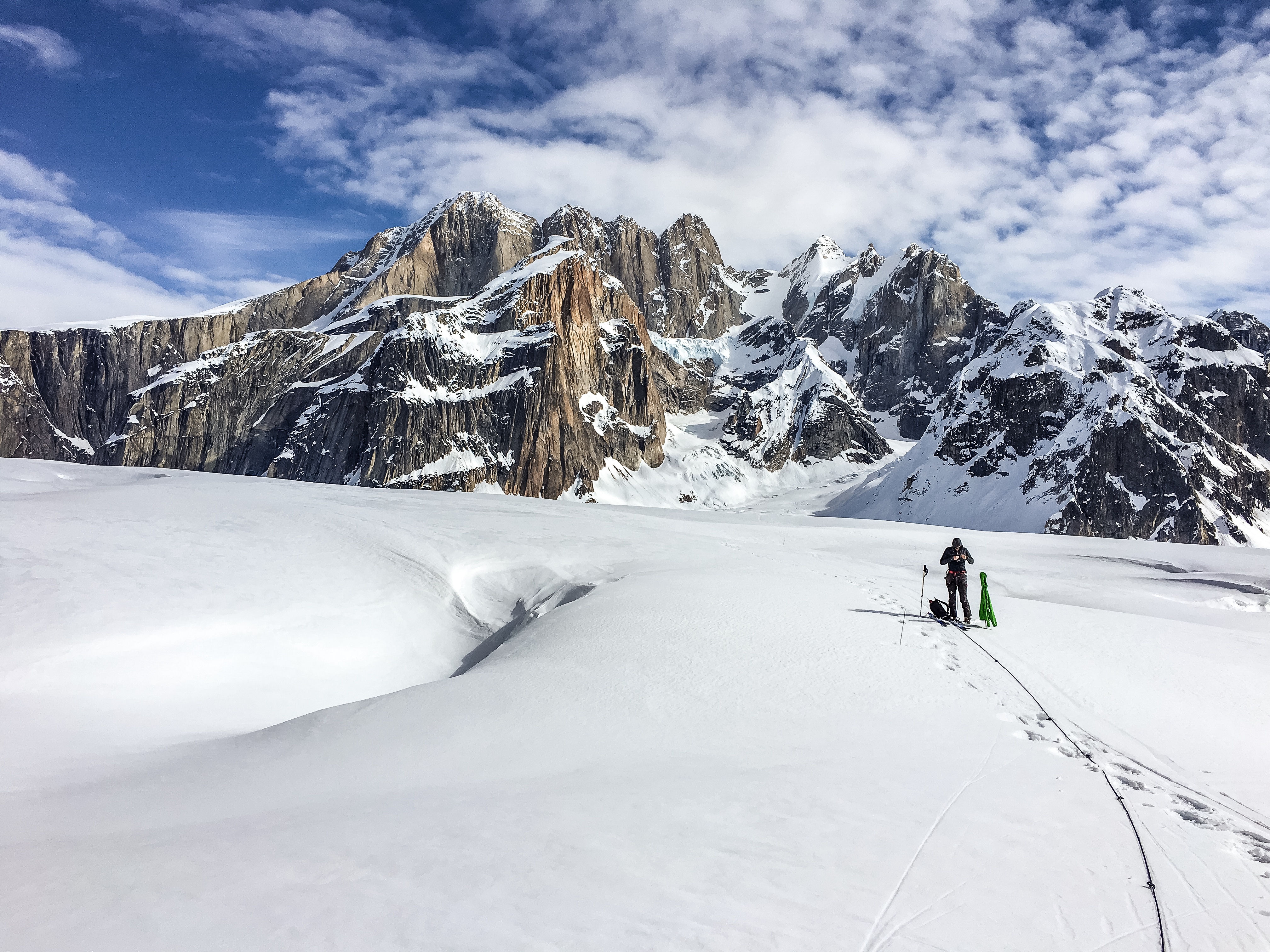 Climber on glacier in foreground of Moose's Tooth