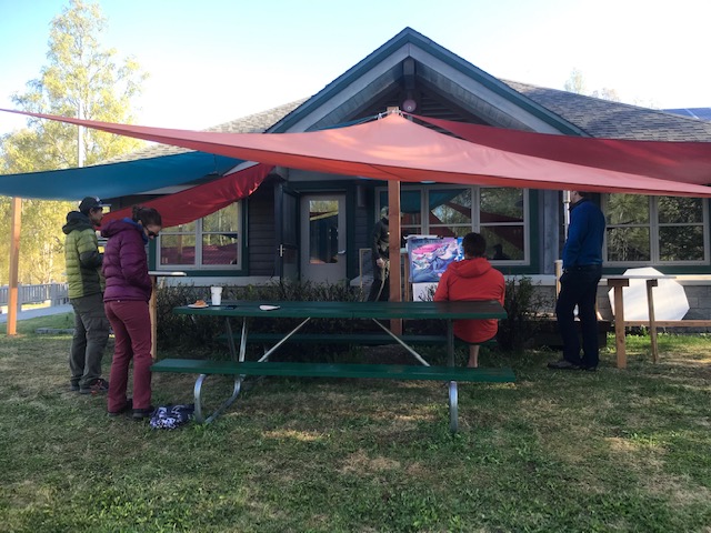 New briefing room Climbers listen to a ranger presentation under colorful sails