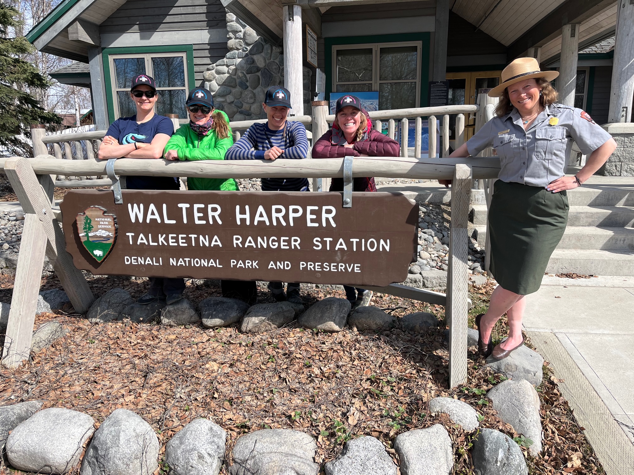 First all-women NPS 14K patrol Five women stand around the Walter Harper Talkeetna Ranger Station sign