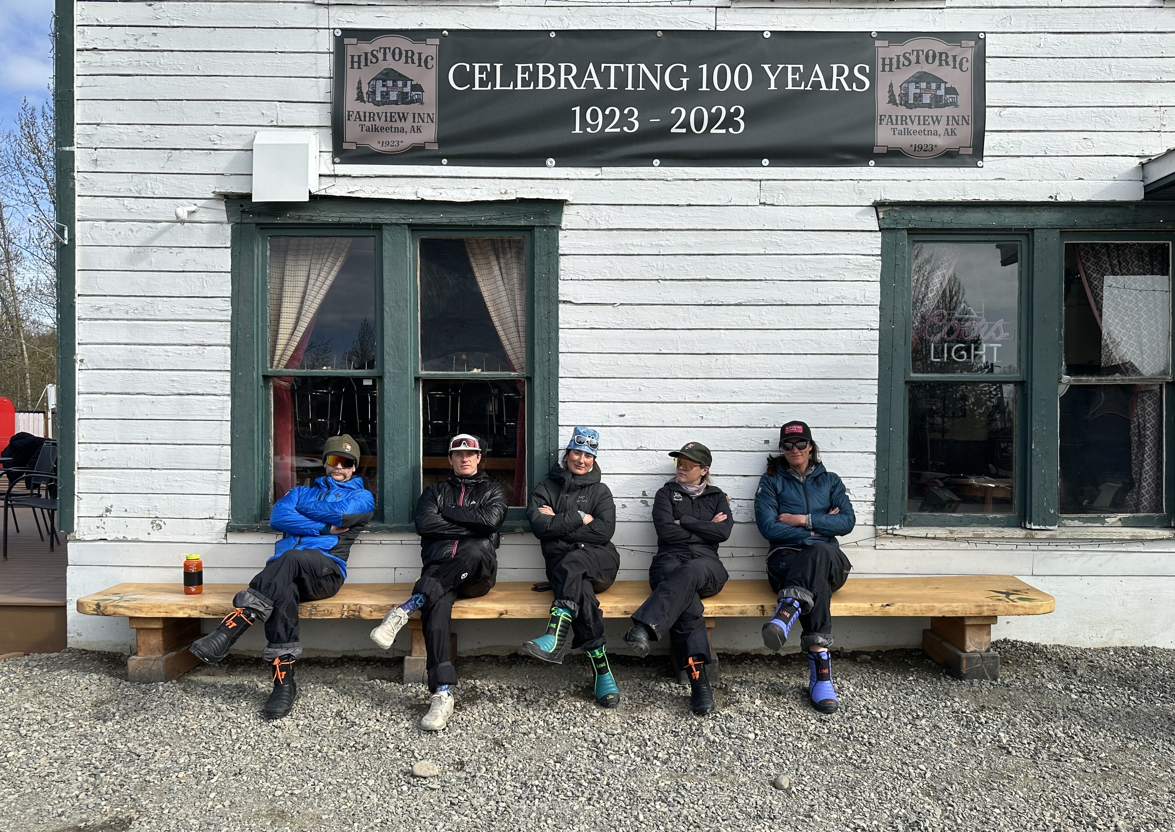 West Buttress Patrol #3 Five climbers sit on a bench with arms crossed and legs crossed
