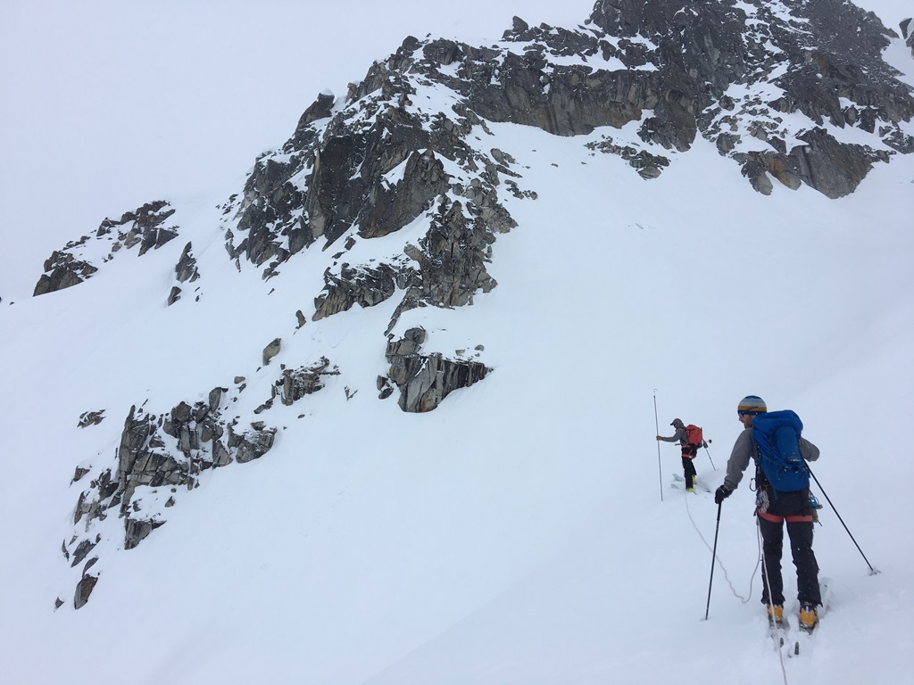 Two rangers assess the snow stability using an avalanche probe
