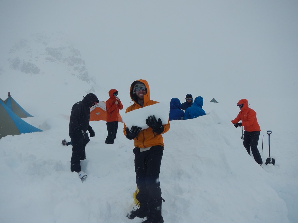 Quinzee construction A team of seven climbers build an igloo under heavy cloud cover.