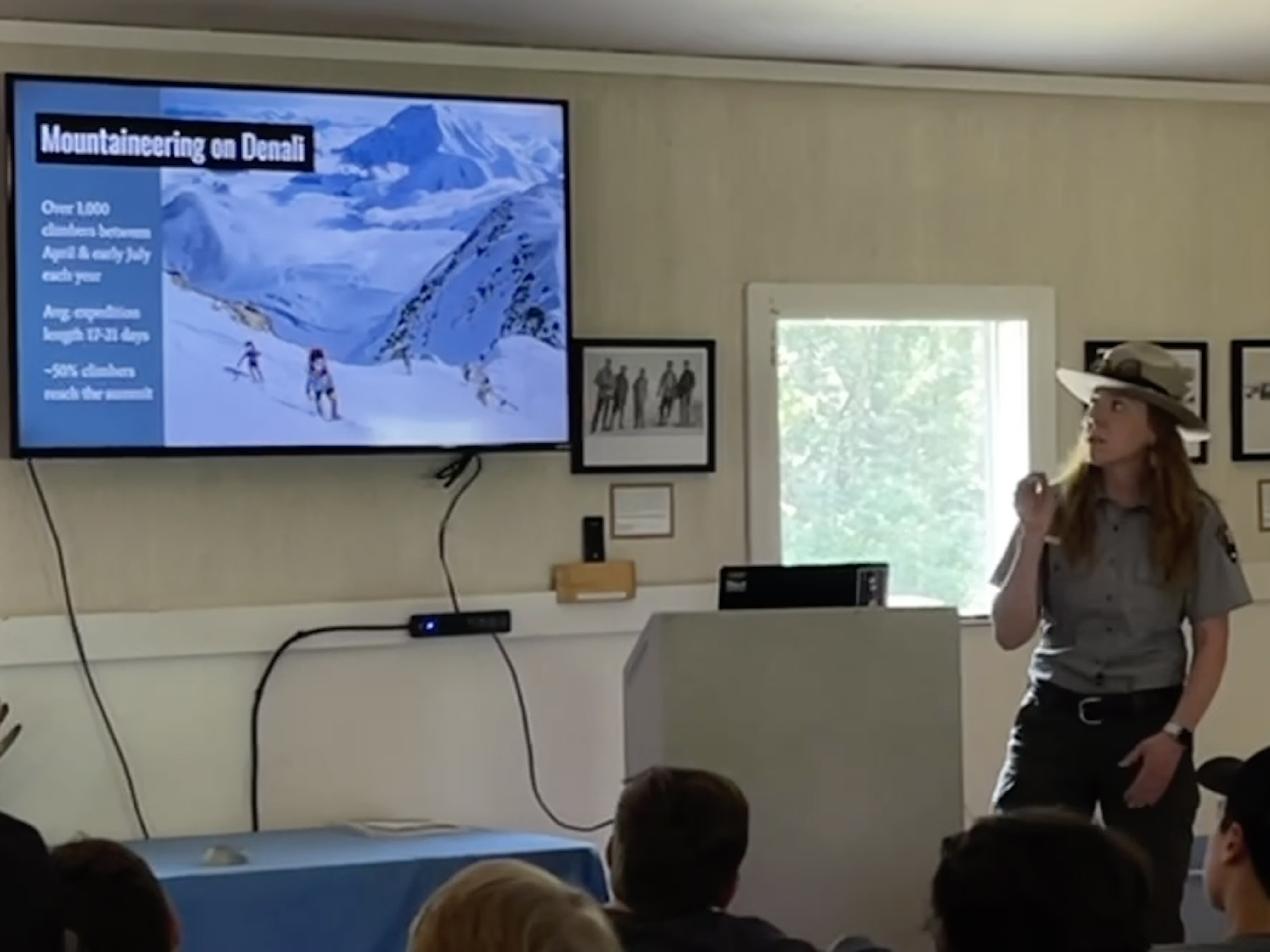 A ranger gives a mountaineering presentation to a seated audience