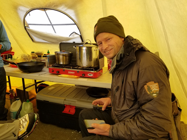 Smiling park ranger in a cooking tent