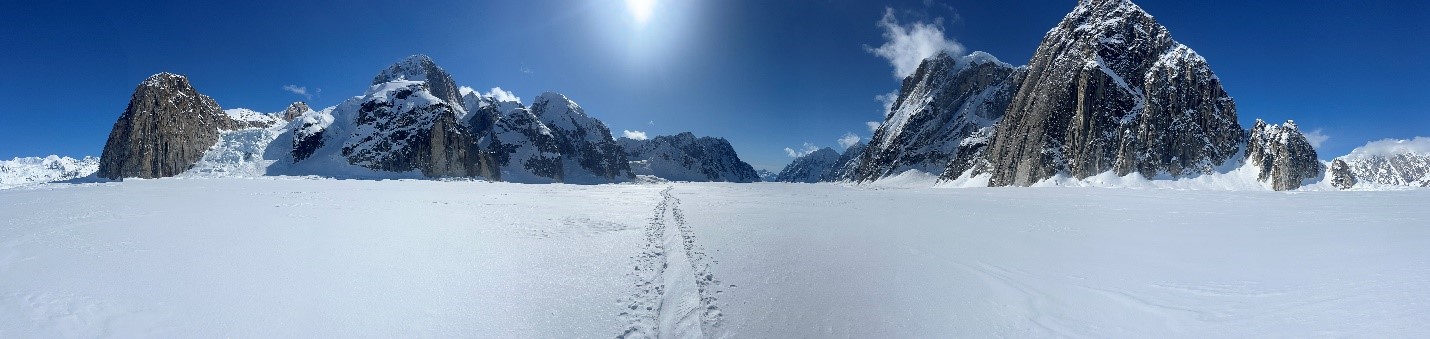 Ruth Gorge from The Gateway Wide shot of a glacier up against a blue sky and bright white sunshine.