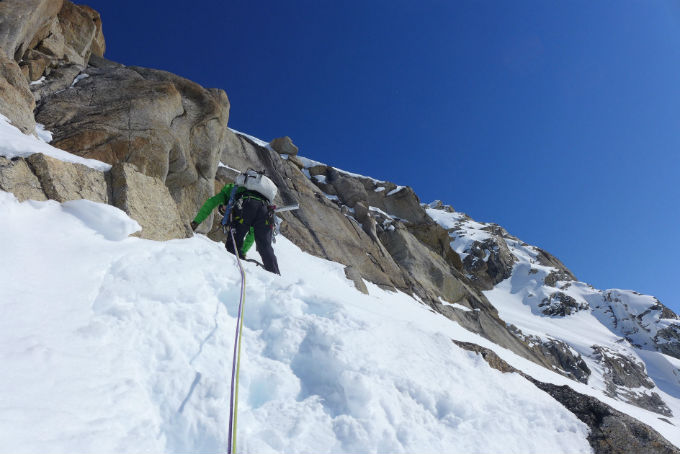 Roped climber on snow and rock Roped climber on snow and rock