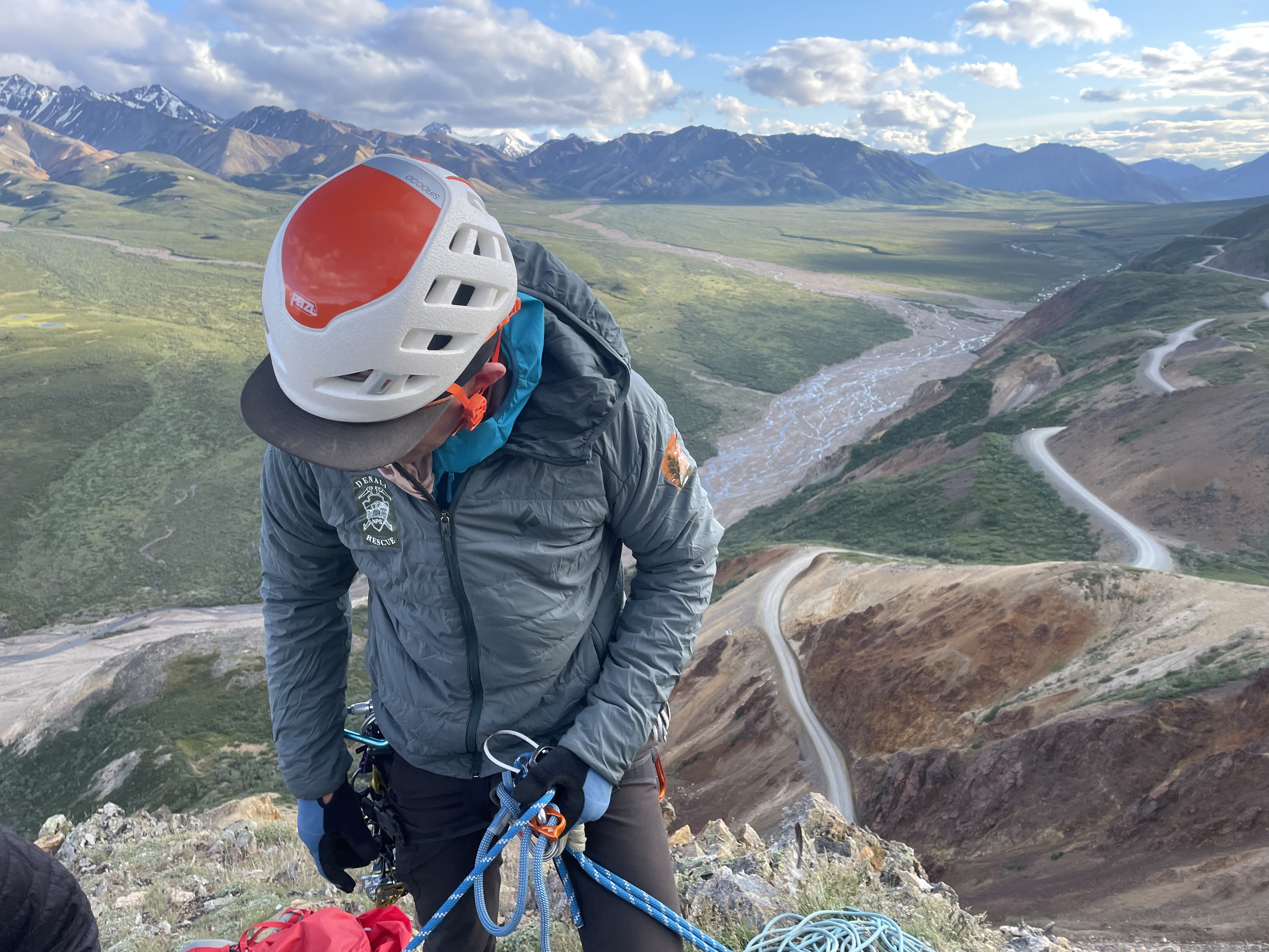 A helmeted ranger checks his rope rigging system