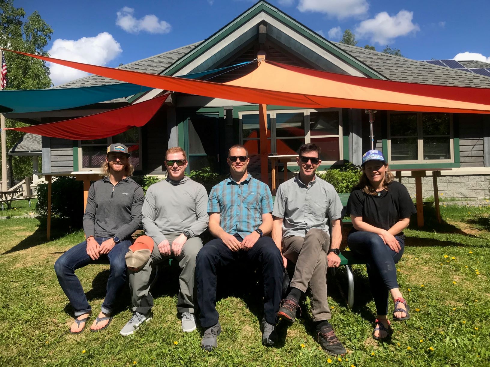 Patrol #4 Five patrollers sit at a picnic table under colorful tarps