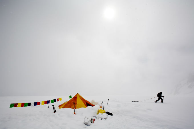Prayer flags and a tent provide a splash of color during a white out