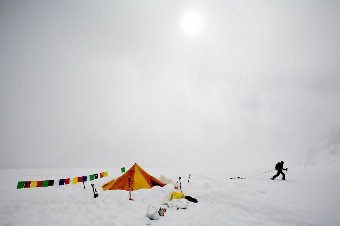 Prayer flags and a tent provide a splash of color during a white out Prayer flags and a tent provide a splash of color during a white out