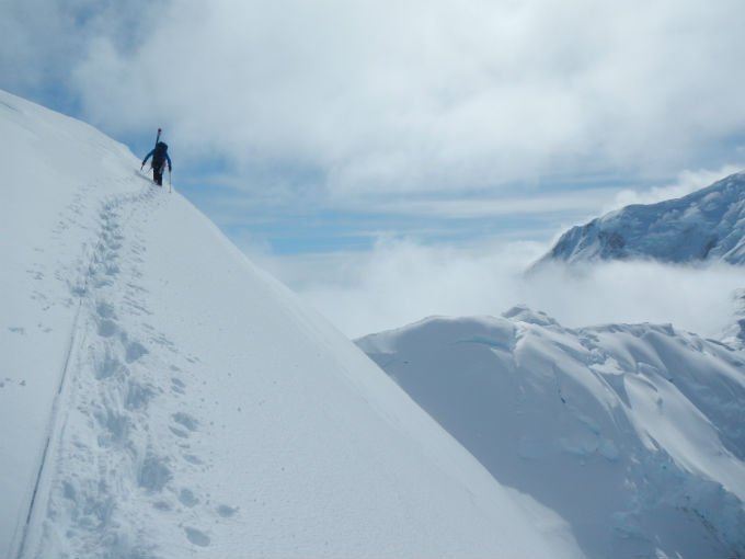 Climber traversing a snowy ridge