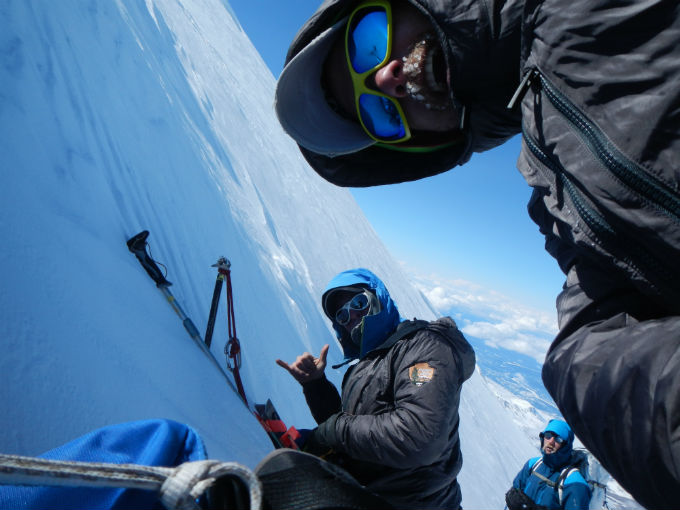 Climbers taking a rest break at base of snow wall