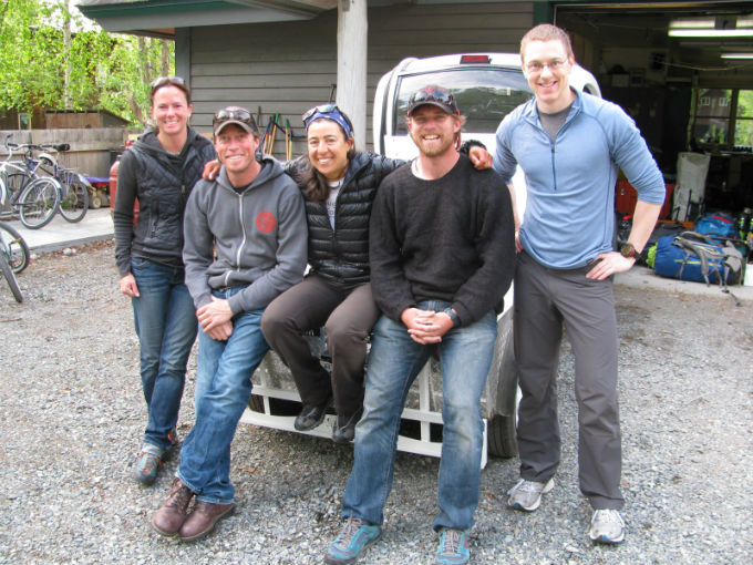 Five patrol members seated on the back of a small truck