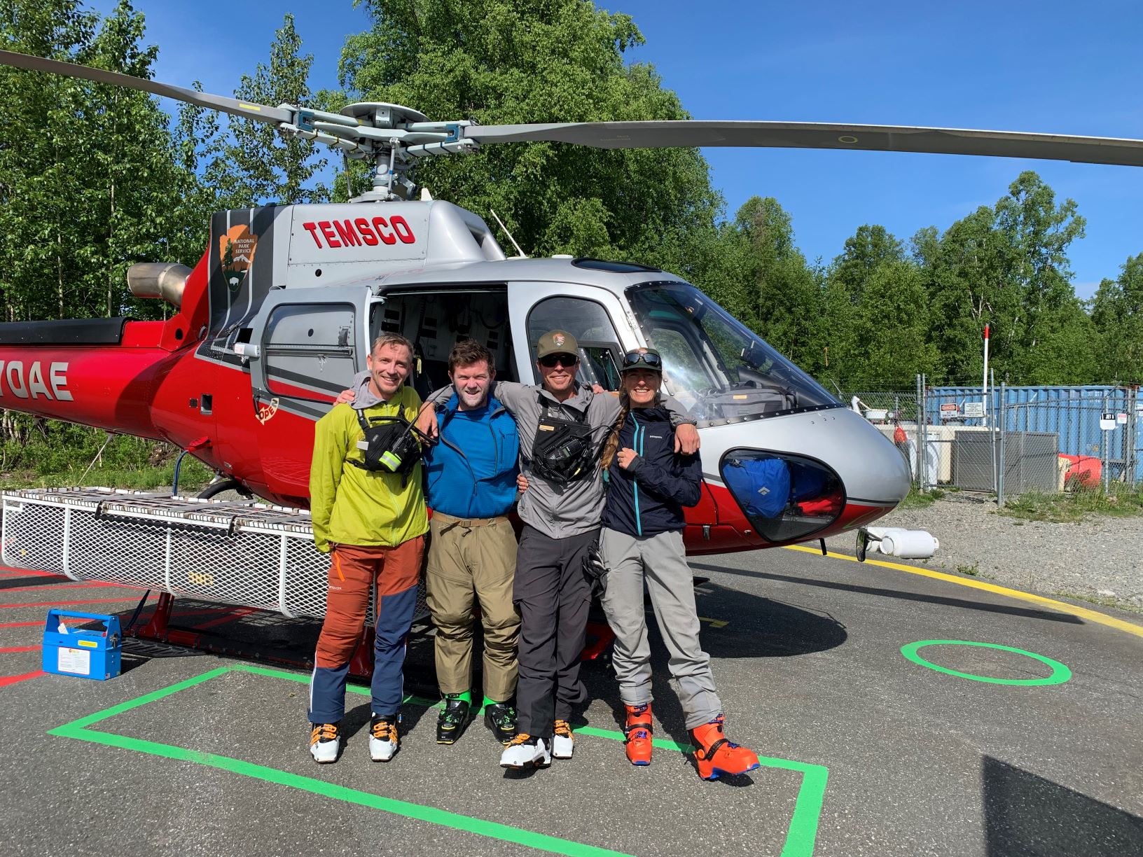 Patrol 5 Four colorfully clad climbers stand outside a helicopter
