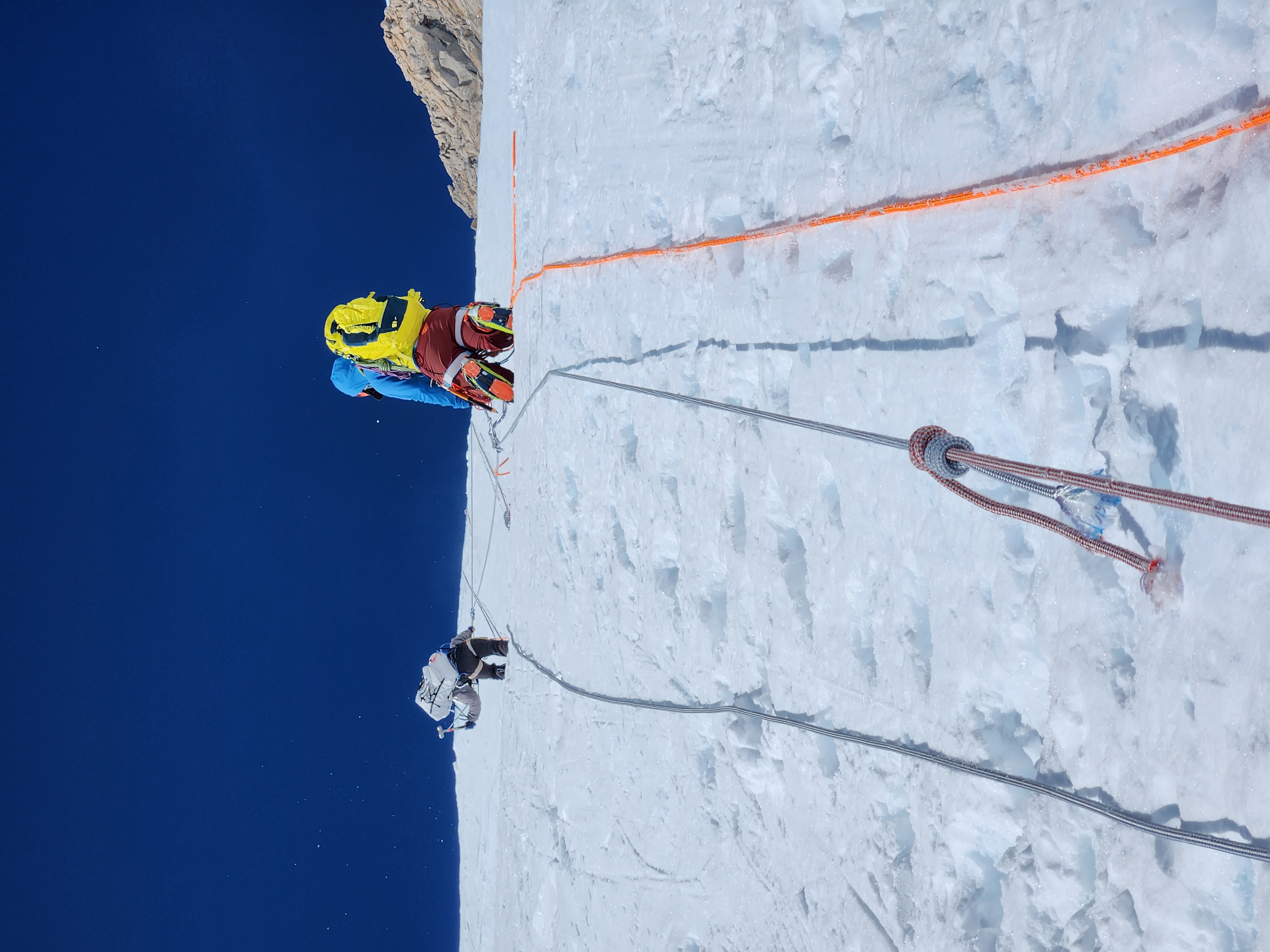 Two Jakes ascending the Fixed Lines A view from below of two climbers ascending a roped slope.