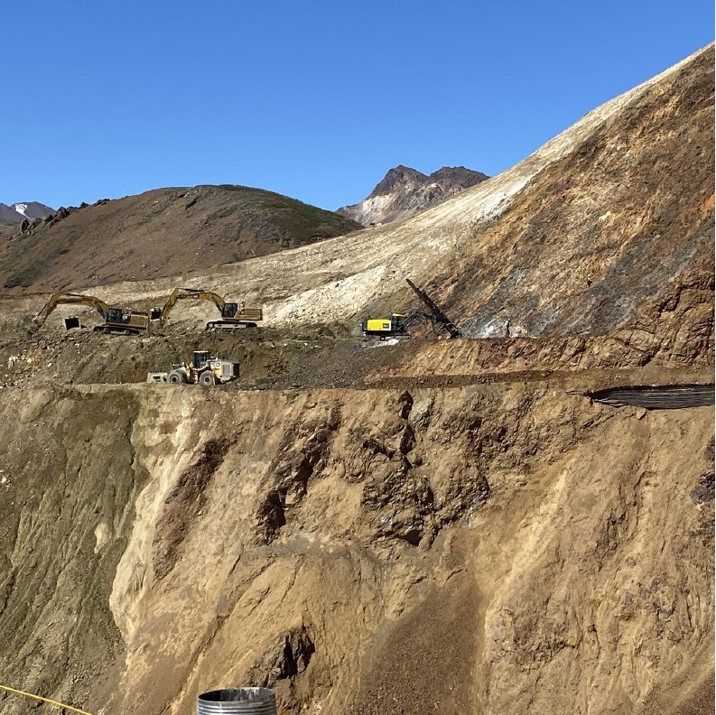 West Cut Excavations and Rock Bolt Drilling - FHWA Photo Four pieces of construction equipment work on a steep, rocky cliffside