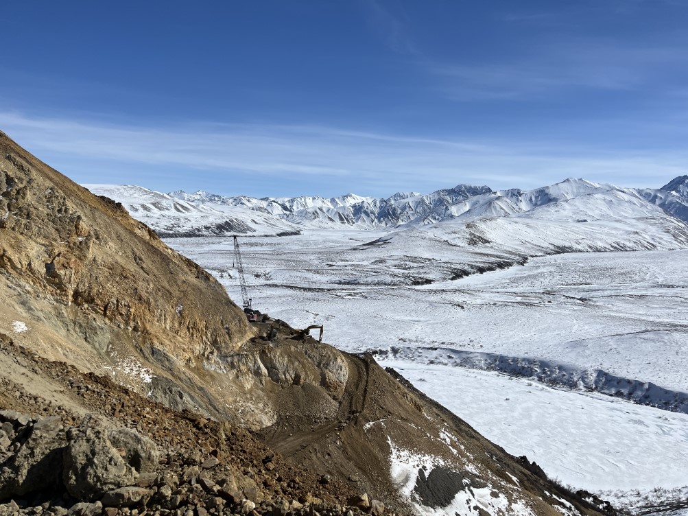 east abutment excavation viewed from west cut FHWA Looking at the east abutment excavation and a crane from the west cut. The mountainside is bare rock but the valley below is still covered in snow.