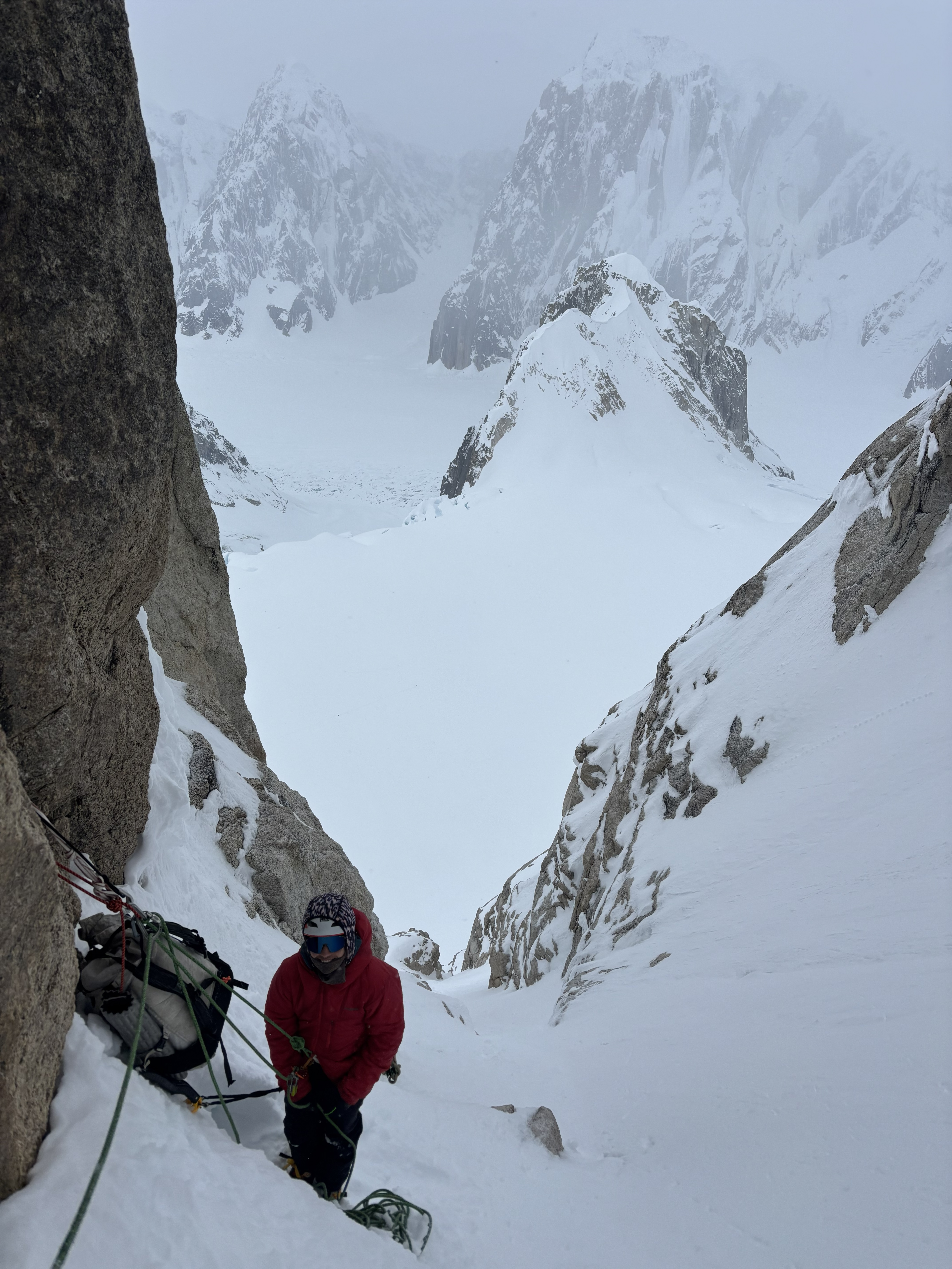 fixed belay-rappel anchors A ranger in a red coat climbing a snowy rock pitch