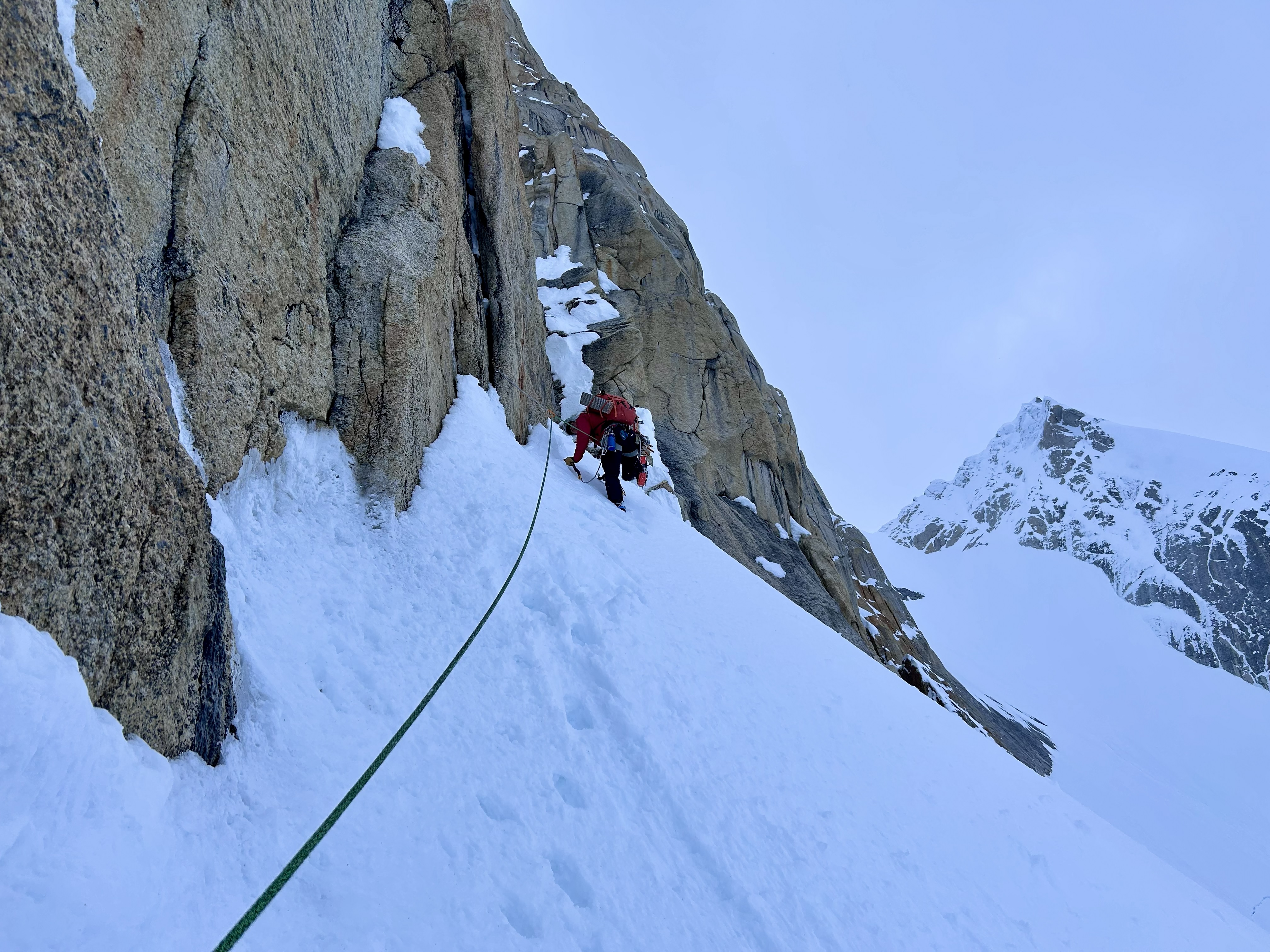 snow traverse at the start of the 2nd pitch A ranger in a red jacket climbs up a snow-covered pitch
