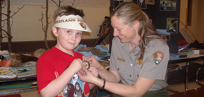 A ranger awards a junior ranger badge to a child