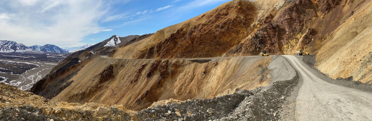 a dirt road precariously situated on the side of a mountain