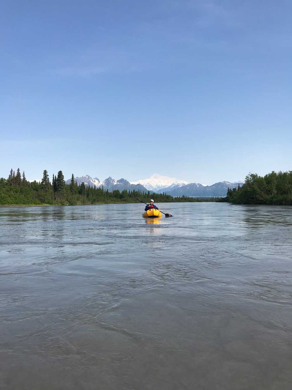 1 person floating on a river in a small raft