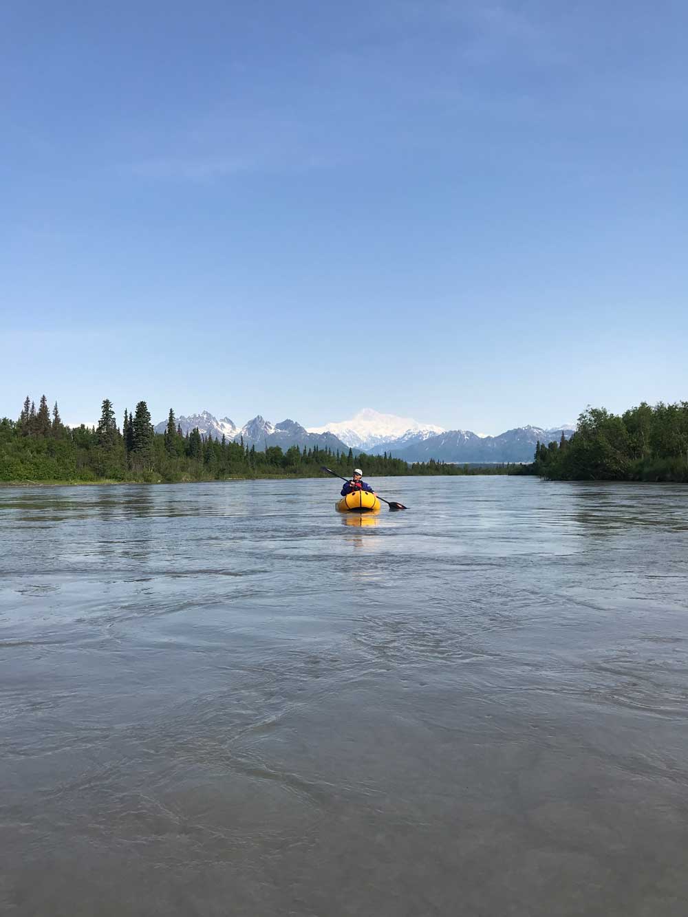 person floating on a river in a small raft