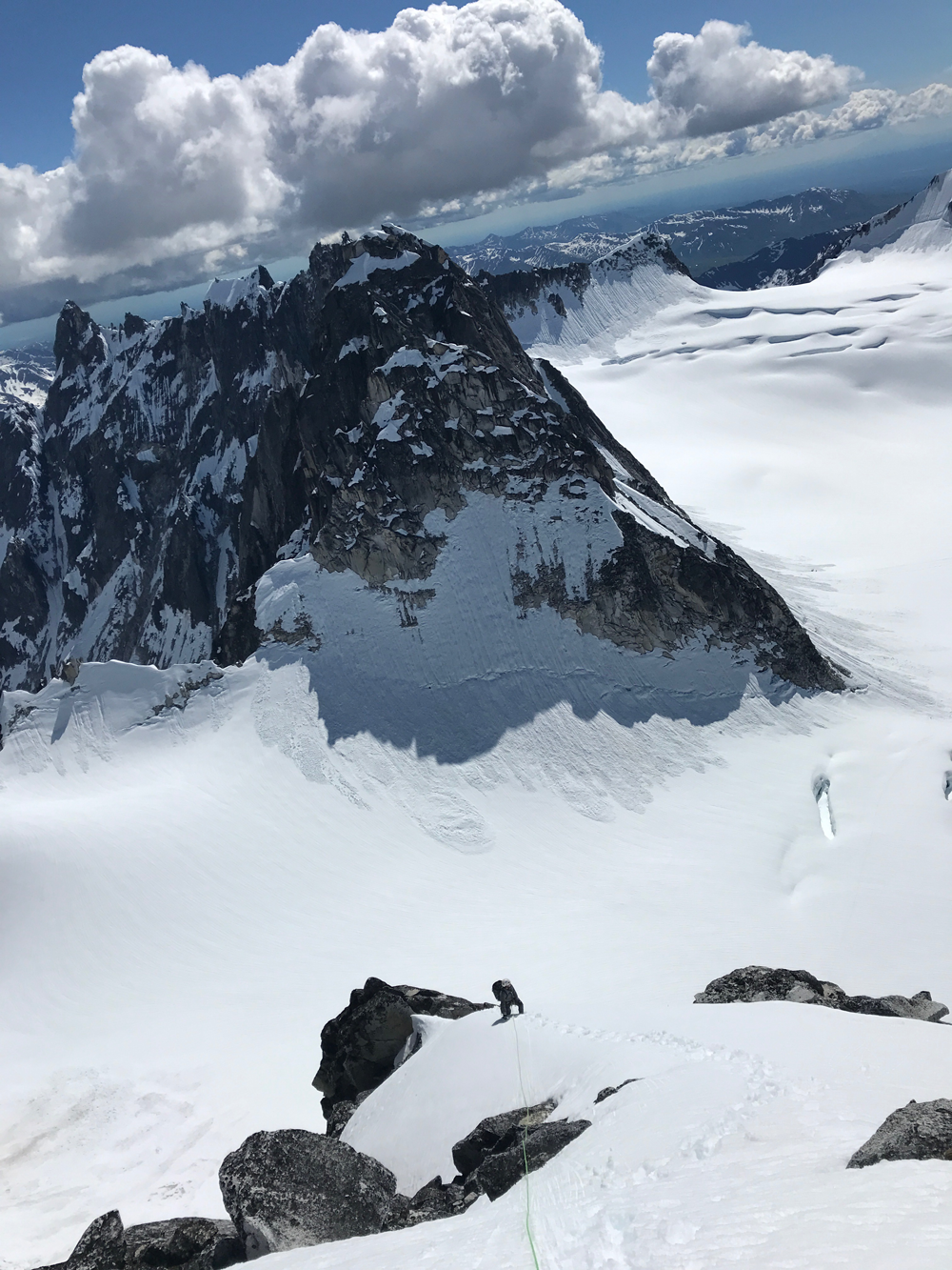 trolls man climbing down a steep, snow-covered mountainside
