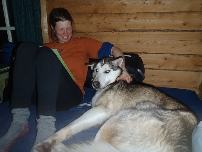 musher and dog relaxing in a cabin