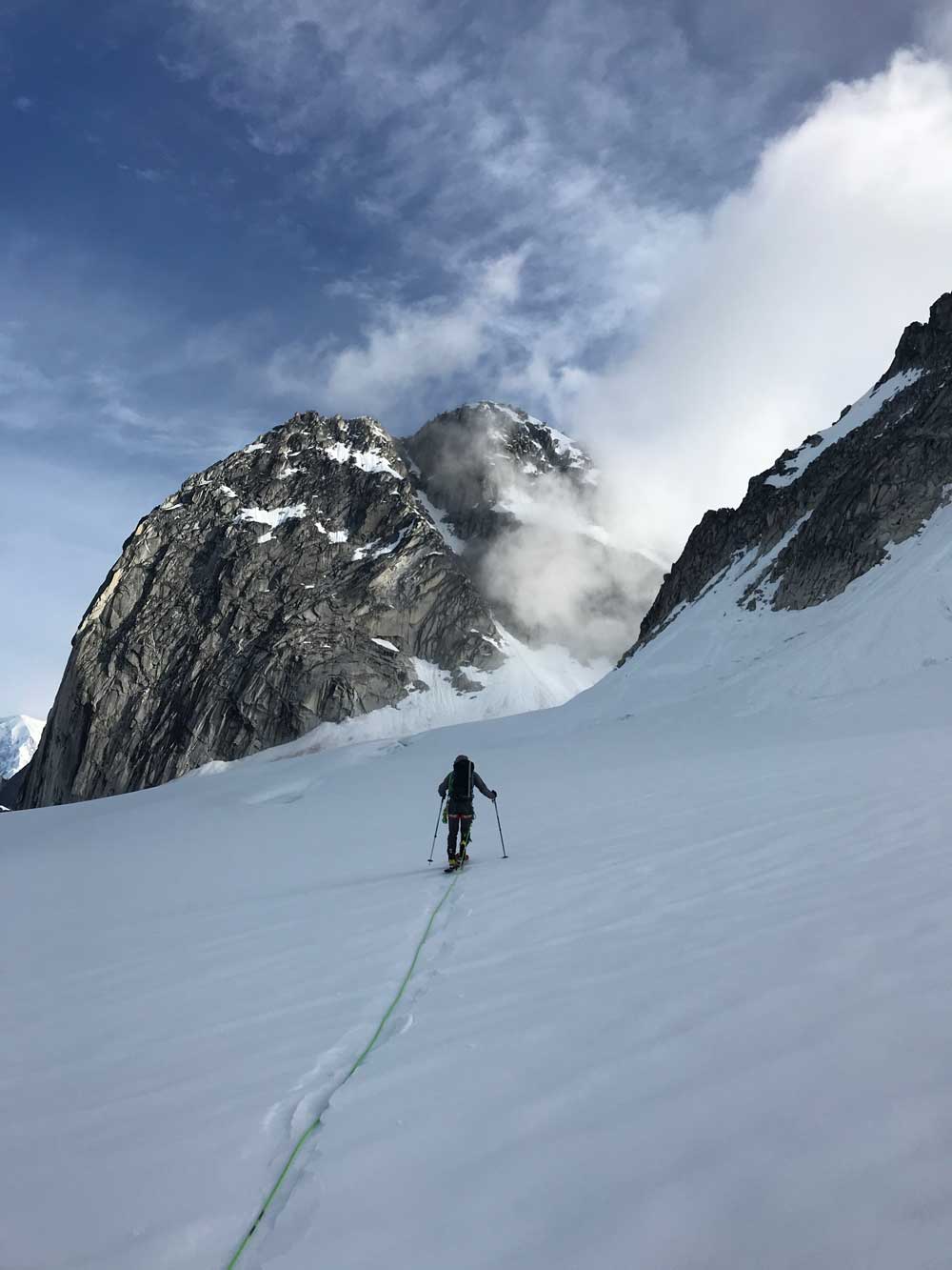 throne man climbing high on a snowy mountain near a craggy peak
