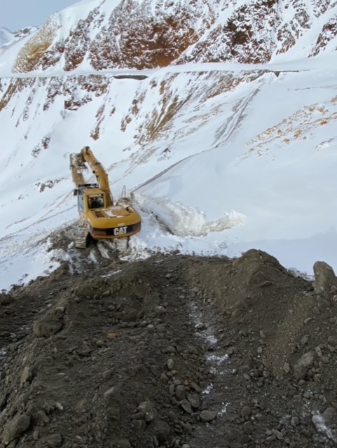 machinery plowing snow off a steep mountainside