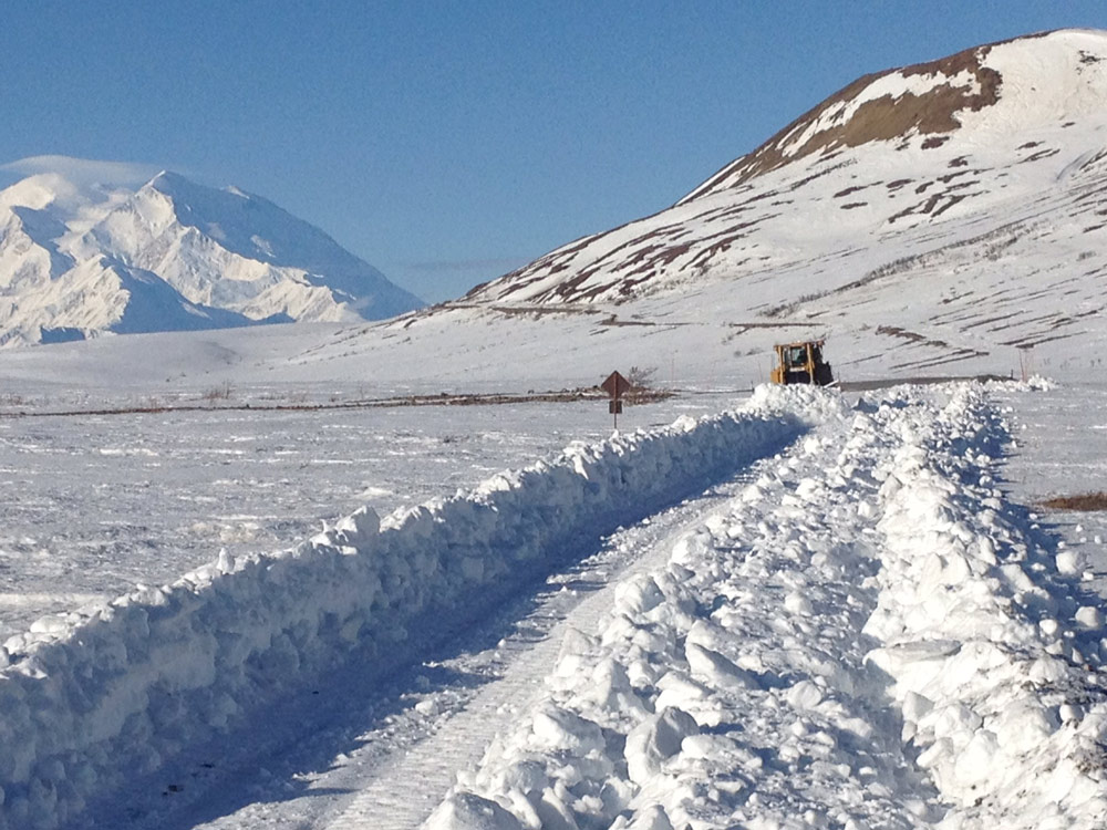 equipment plowing up a snowy mountainside equipment plowing up a snowy mountainside