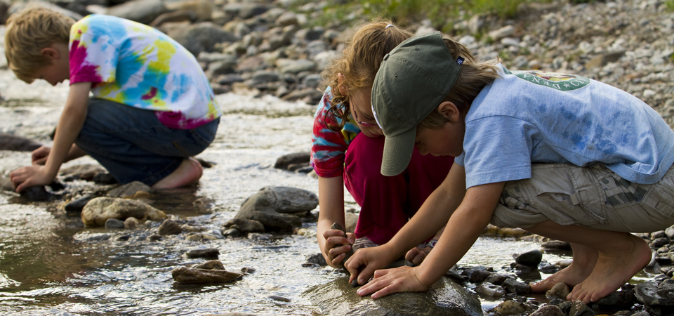 children play in a rocky creek children play in a rocky creek