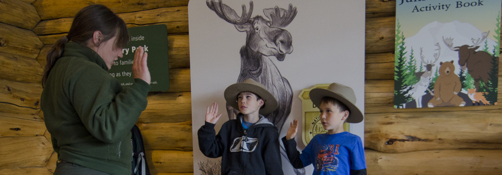 two junior rangers are sworn in by a park ranger two junior rangers are sworn in by a park ranger