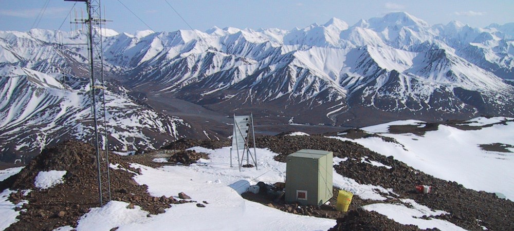 an earthquake station sits on a snowy mountainside