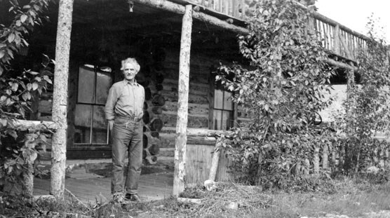 Historic image of man and cabin Historic image of man and cabin
