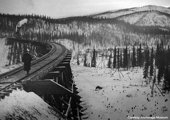 Historic image of person walking along a trail trestle Historic image of person walking along a trail trestle