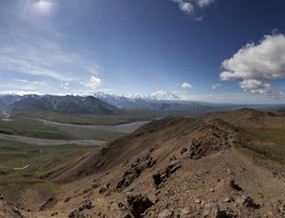 panoramic image from atop a ridge, looking at distant mountains