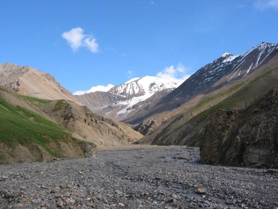 a gravel river bar emerging from steep mountains