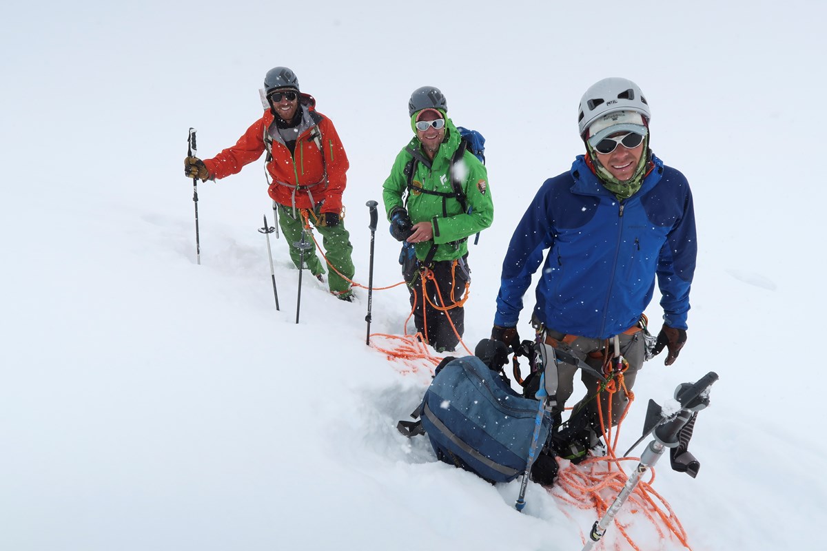 Three climbers take a break on a snowy day Three climbers take a break on a snowy day