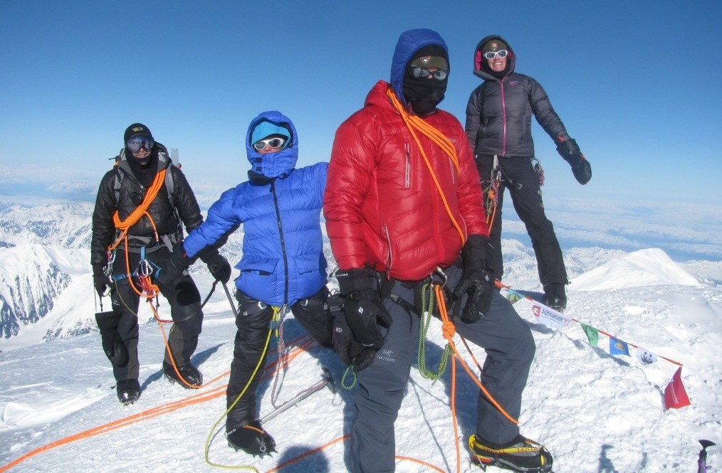 Climbers on summit wearing extreme cold weather gear